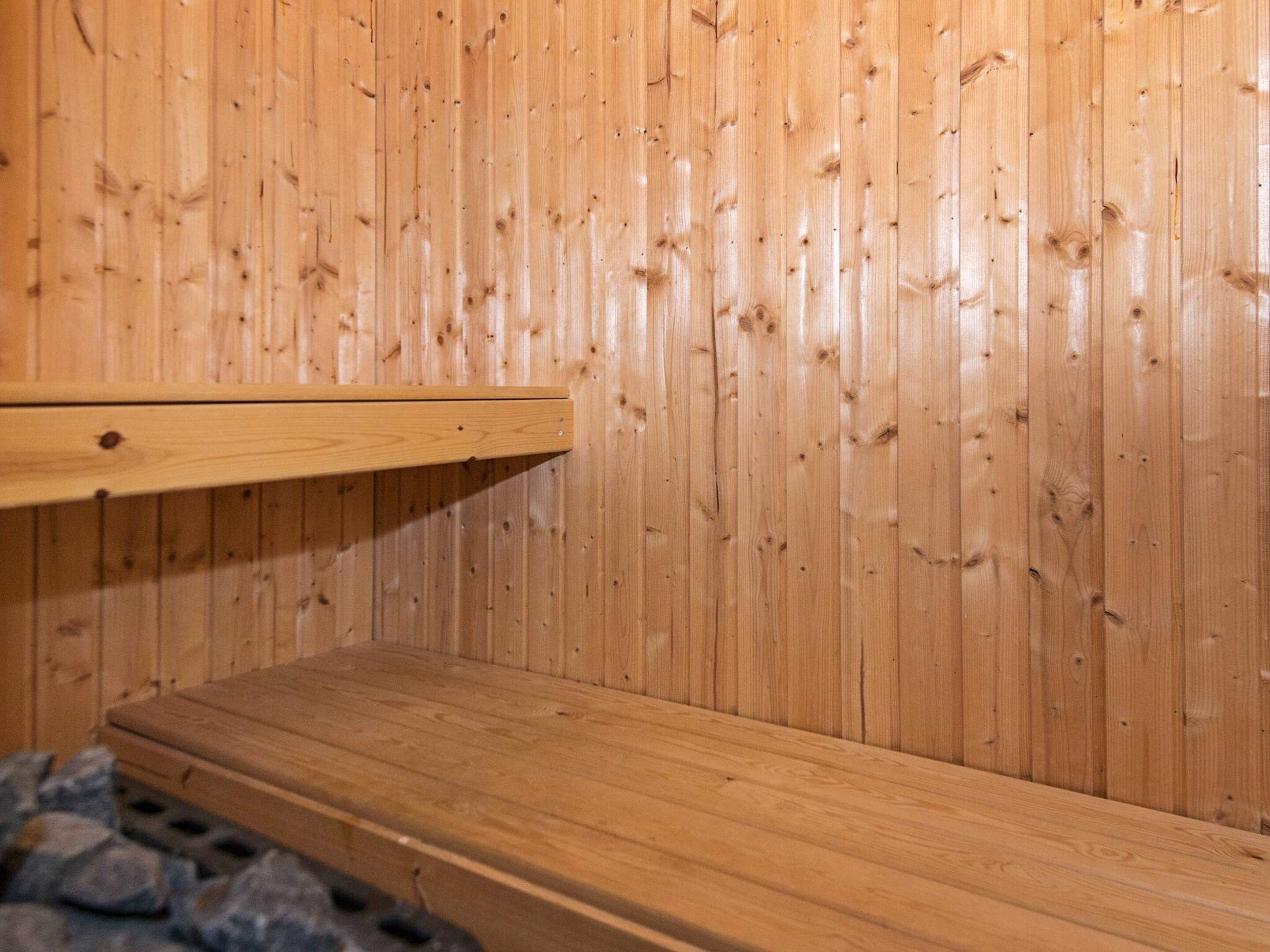 Eine Holzsauna mit einer Sitzbank und Ablagefläche.