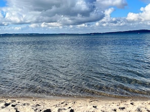 A beach with clear water, a sandy shore, and distant land. - 4 Star Holiday Home in Ebeltoft (Ebeltoft)