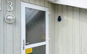 A white door with a glass panel, a number '3' sign, and a blue object on the wall.