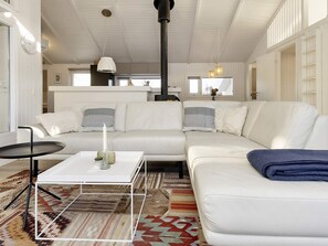 A modern living room with a white sofa, a coffee table, and a patterned rug.