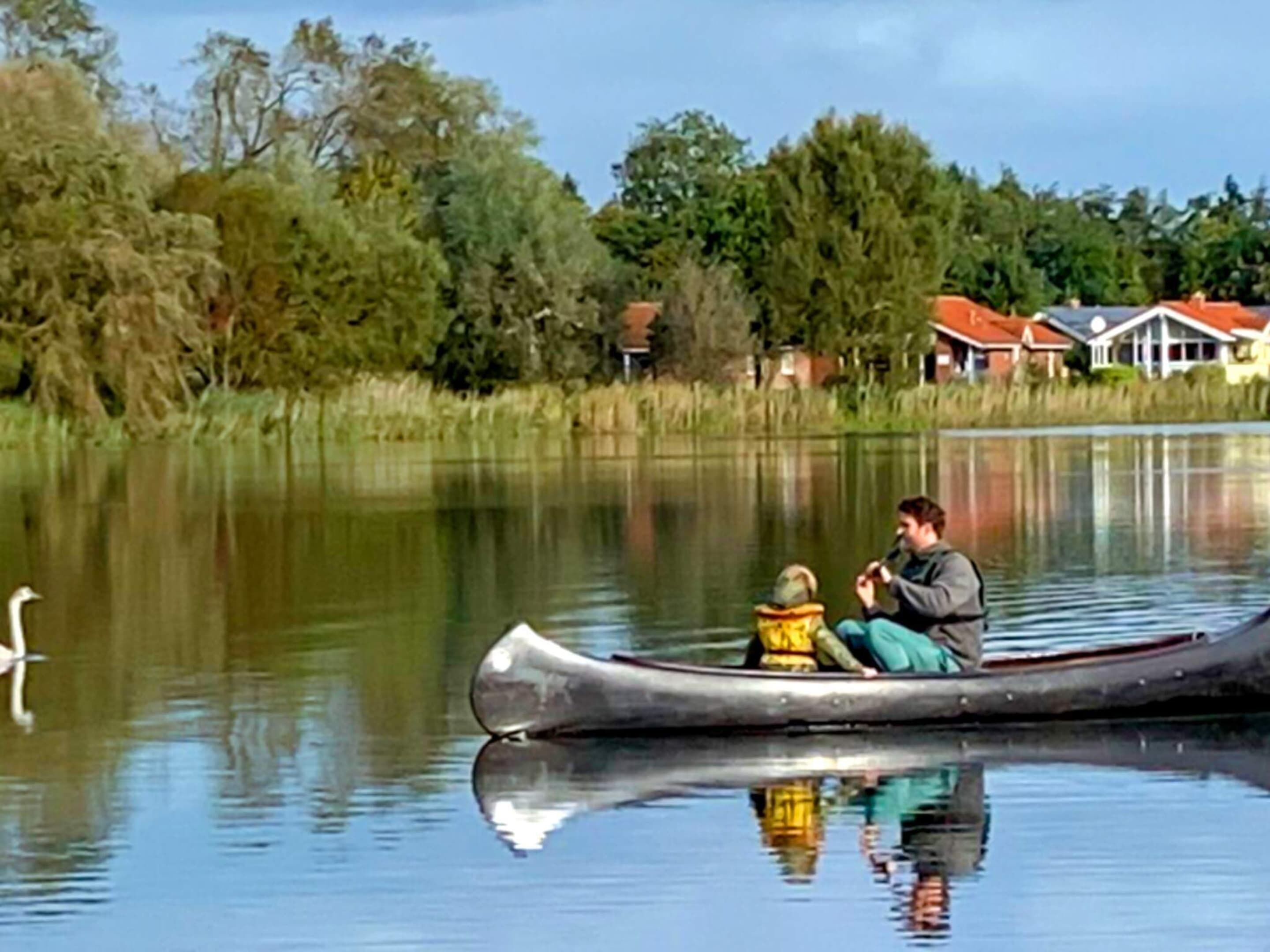 A calm lake with a canoe and a person.