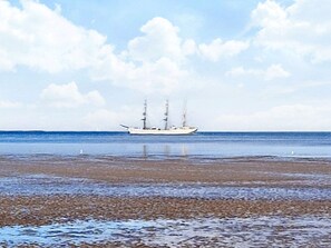 Un grand navire sur des eaux calmes, sous un ciel dégagé.