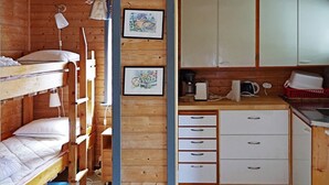 Een compacte kamer met stapelbedden, een kitchenette en een kleine badkamer.