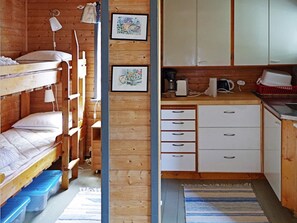 A compact room with bunk beds, a kitchenette, and a small bathroom. - 4 Person Holiday Home in Hamburgsund (Hamburgsund)
