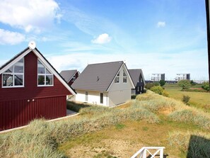 A row of modern houses with sloped roofs and satellite dishes, set in a grassy area with a clear sky. - Holiday Home in Wendtorf (Wendtorf)