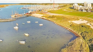 A marina with boats docked, a pier, and a construction crane in the background. - Holiday Home in Wendtorf (Wendtorf)