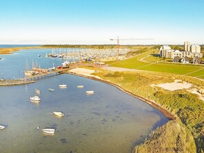 A marina with boats docked, a pier, and a construction crane in the background. - Holiday Home in Wendtorf (Wendtorf)