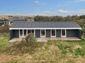A modern house with a flat roof, large windows, and a wooden deck. - Cozy Holiday Home in Lokken near Coast (Lokken)