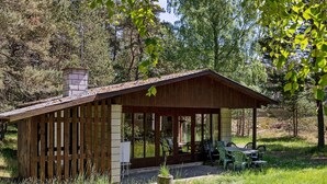 A rustic cabin with a covered porch, wooden walls, and a chimney. - Cozy Holiday Home in Nexo near Dueodde Beach (Nexø)