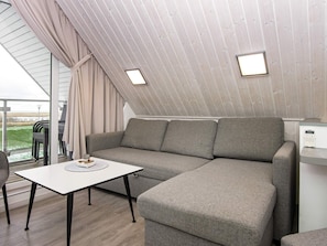 Een moderne, gezellige zithoek met een hoekbank, een klein tafeltje en uitzicht op de omgeving.