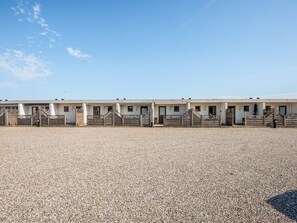A row of equestrian stables with individual doors and gates.