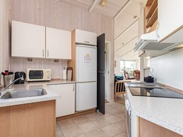 Cocina compacta con refrigerador, microondas y lavamanos.