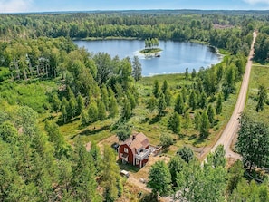 A rural landscape with a lake, a red barn, and a dirt road. - 4 Star Holiday Home in Sturefors (Sturefors)