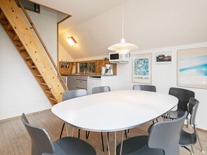 A modern kitchen with a microwave, coffee maker, and wooden cabinets.