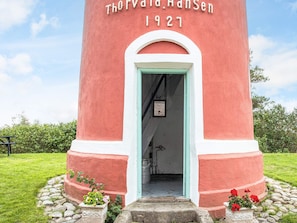 Una estructura cilíndrica roja y blanca con la inscripción 'Thorvald Hansen 1927' en la parte superior.