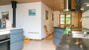 Een moderne keuken met een centraal eiland, een ingebouwde oven en een groot raam voor natuurlijk licht.