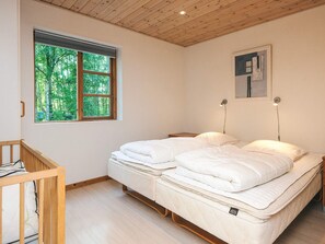 A bedroom with a double bed, a window with a view of trees, and a painting on the wall. - Cozy Holiday Home in Nordjylland near Sea (Læsø)