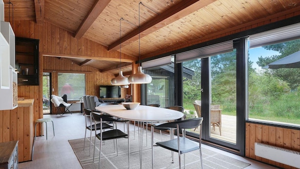 Una cucina moderna con una grande isola, travi in legno al soffitto e vista sull'esterno.