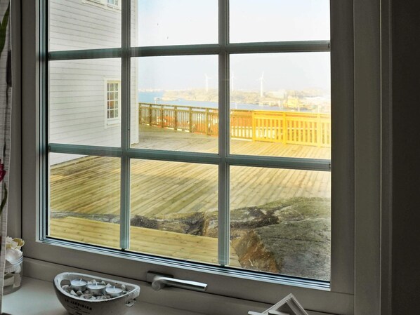 A window with a view of a wooden deck and a yellow fence. - Holiday Home in Rönnäng (Roennaeng)