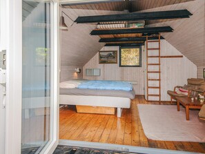 A bedroom with a bed, a desk, a chair, a ladder, and a window. - 6 Person Holiday Home in Fano (Fano)