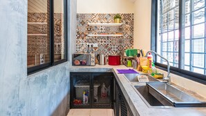 Una cucina con schienale piastrellato, forno a microonde integrato e lavandino.