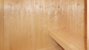 A wooden sauna with benches and a sloped floor. - Holiday Home in Wendtorf (Wendtorf)