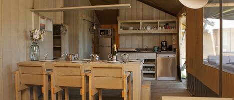 A spacious kitchen with wooden cabinets, a dining area with a table and chairs, and a large window providing natural light.