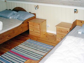 A room with two wooden beds, a small wooden dresser, and a striped rug. - 10 Person Holiday Home in Hovden (Bykle)