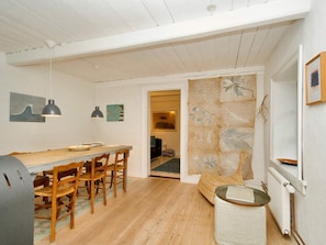 A dining area with a wooden table and chairs, a grill, and pendant lighting. - 2 Person Holiday Home in Gilleleje (Gilleleje)