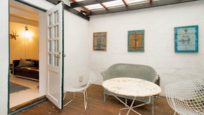 A cozy room with a wooden floor, a round table, two chairs, and a door leading to another room. - 2 Person Holiday Home in Gilleleje (Gilleleje)