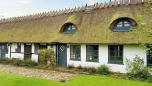 A traditional thatched-roof cottage with a stone pathway leading to the entrance. - 2 Person Holiday Home in Gilleleje (Gilleleje)