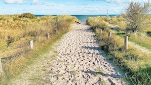 A sandy pathway leading to the beach, flanked by grassy dunes and wooden posts. - 8 Person Holiday Home in Gedser-by Traum (Gedser)