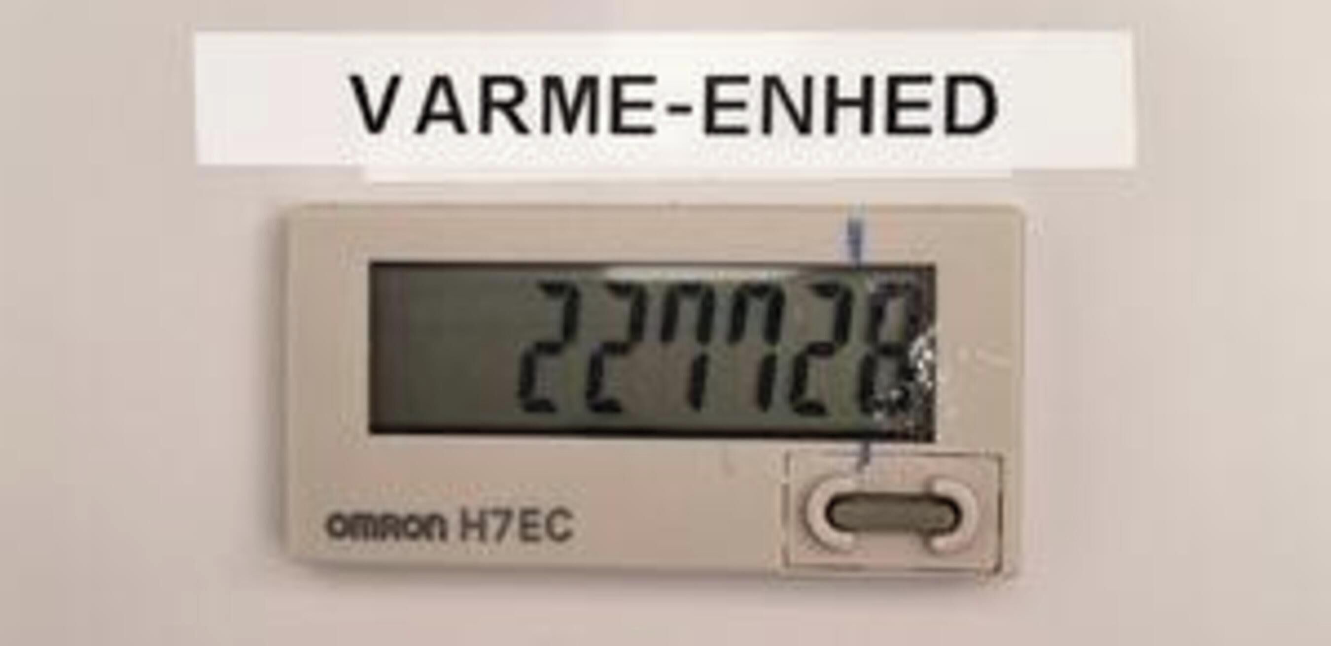 A digital thermometer with 'VARME-ENHED' label and 'omron H7EC' brand, displaying a temperature of 22.1°C.