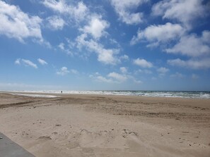 A wide sandy beach with footprints leading to the water, under a partly cloudy sky. - 5 Star Holiday Home in Lokken (Lokken)