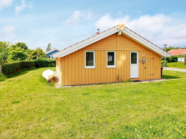 A small wooden building with a gabled roof, a door, and two windows. - Holiday Home in Gelting (Gelting)