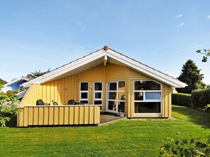 A single-story wooden house with a gabled roof, large windows, and a small porch area. - Holiday Home in Gelting (Gelting)
