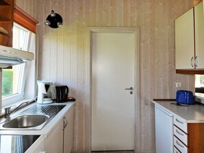 A compact kitchen with a built-in oven, a coffee maker, and a sink. - Holiday Home in Gelting (Gelting)