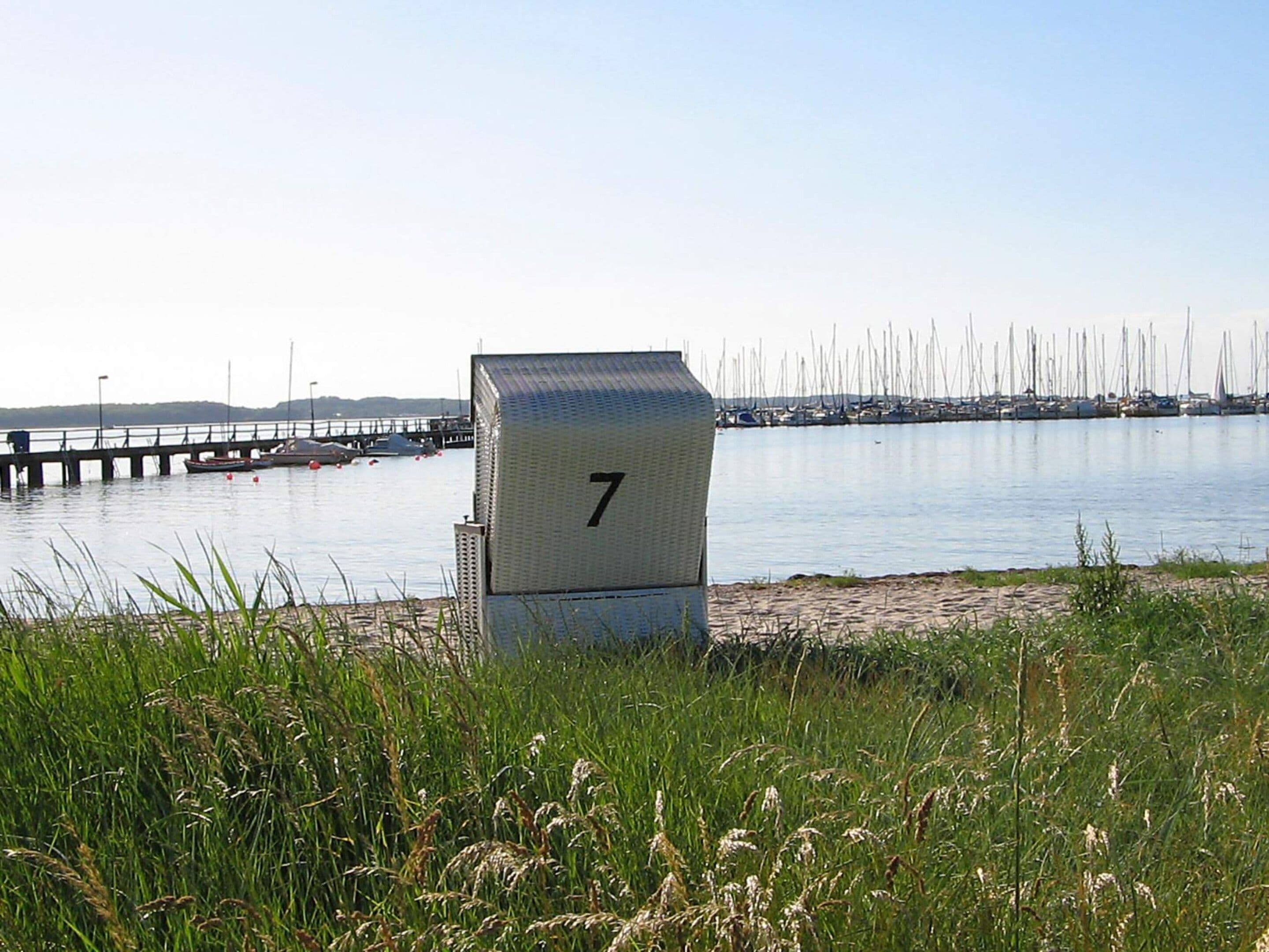 Une propriété située en bord de mer, avec un panneau portant le numéro 7, une jetée et une marina en arrière-plan.
