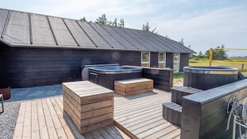 En træterrasse med boblebade og et overdækket område.