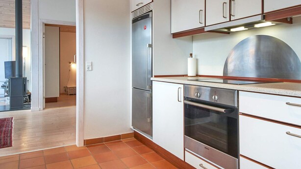 A kitchen with white cabinets, a Bosch oven, and a stainless steel refrigerator. - 4 Star Holiday Home in Allinge (Allinge)