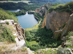 A natural landscape with a river, cliffs, and greenery.