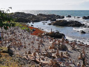 A rocky shoreline with balanced stone stacks and a view of the ocean. - 4 Star Holiday Home in Allinge (Allinge)