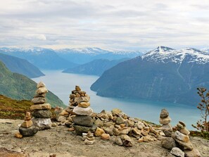 A mountainous landscape with a clear lake and stacks of rocks. - 4 Person Holiday Home in HÃ¸yheimsvik (Luster)
