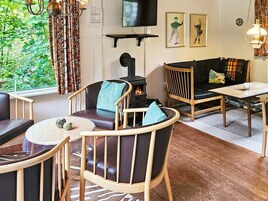 Una sala de estar acogedora con chimenea, asientos cómodos y televisor.