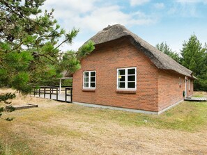 A small brick house with a thatched roof, two windows, and a wooden deck. - Comfortable Holiday Home in Rømø With Sauna (Rømø)