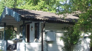 A single-story house with a porch, a small window, and a utility box. - 3 Person Holiday Home in Vastervik (Vastervik)