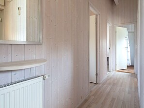 A hallway with wooden paneling, a radiator, and a door leading to another room. - Holiday Home in GrÃ¶mmitz (Groemitz)