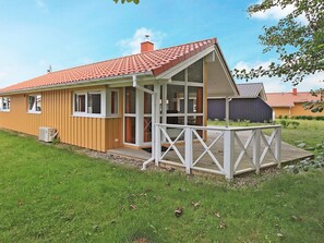 A single-story house with a red-tiled roof, a covered porch, and a fenced yard.