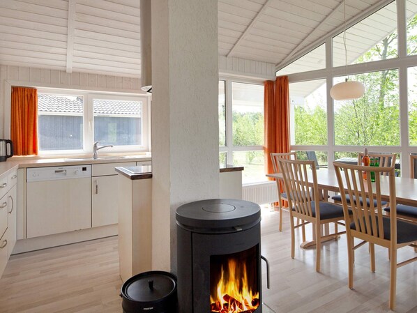 A modern kitchen with a built-in stove, wooden dining table, and chairs.