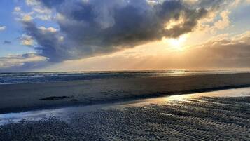 A beach with waves and a cloudy sky.